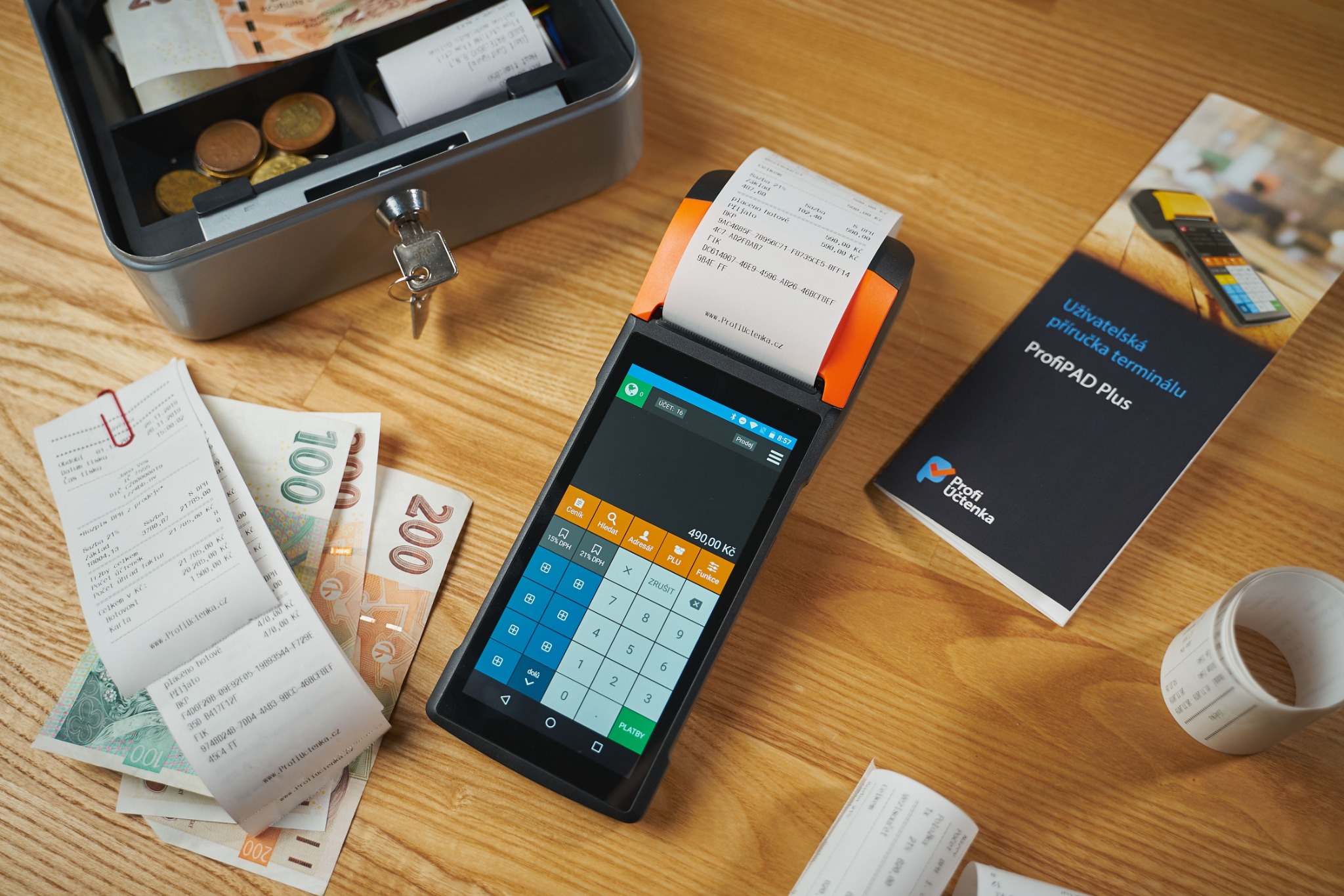 Receipts, cash, and a payment terminal on a wooden counter